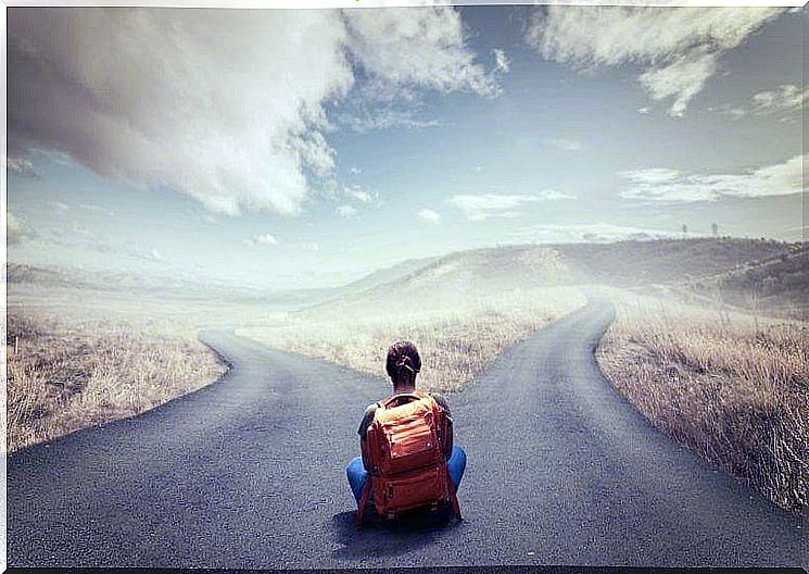 Woman with backpack in front of two roads