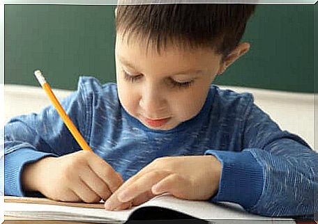 Child writes in notebook with pencil.