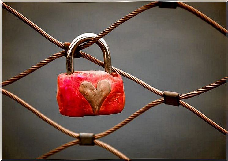 Padlock with a heart drawn on it hanging from a rope