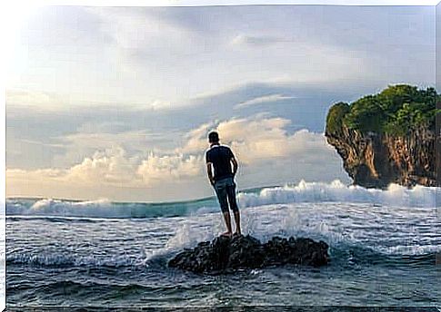 Boy watching the sea from a rock.