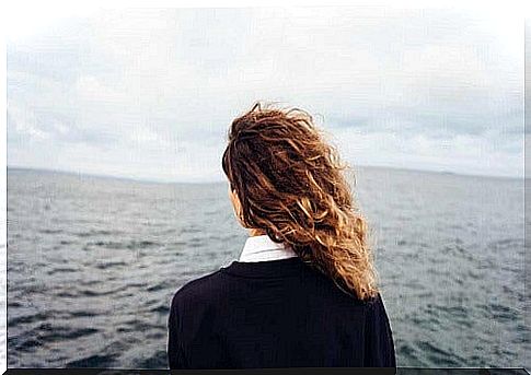 Girl from behind in front of the sea.