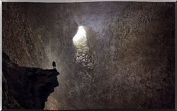 Man inside cave looking way out