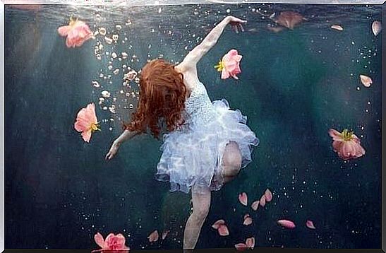 Girl underwater surrounded by flowers