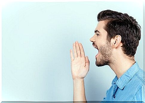 Man screaming with hand near mouth