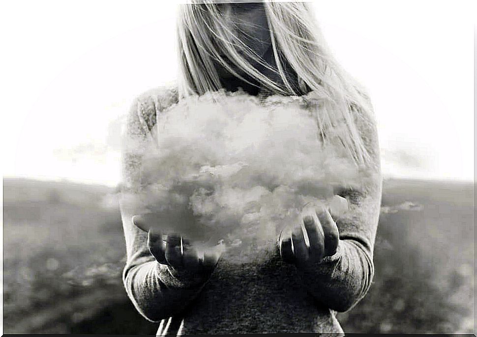 Woman holds up cloud representing her negative thoughts.